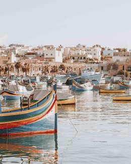 Colorful typical boats - Mediterranean traditional fisherman village in the south east of Malta. Early winter morning in Marsaxlokk, Malta.